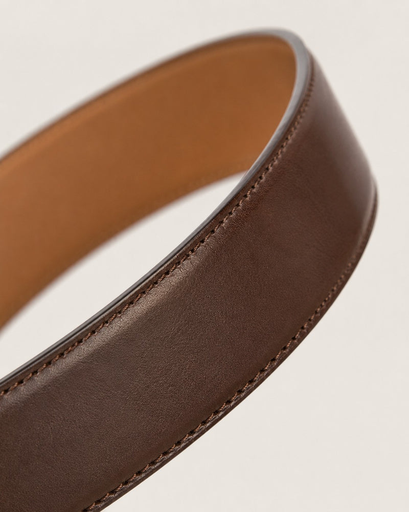 Edge-on macro photograph of the sealed, burnished and stitched edge of a brown Harrow belt